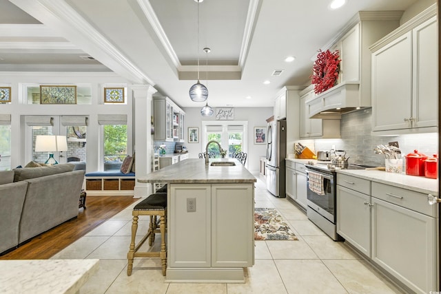 175 Chapel Creek Rd, Pawleys Island, SC 29585 - kitchen with appliances with stainless steel finishes, open floor plan, a kitchen bar, a tray ceiling, and ornamental molding