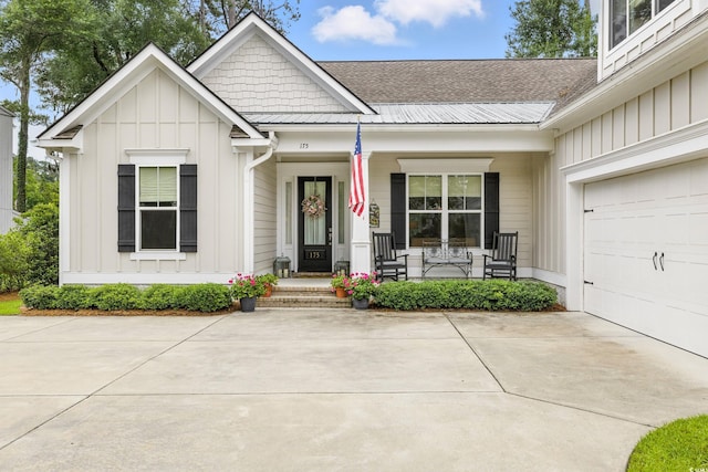 175 Chapel Creek Rd, Pawleys Island, SC 29585 - view of front of house with board and batten siding, covered porch, a garage, and roof with shingles