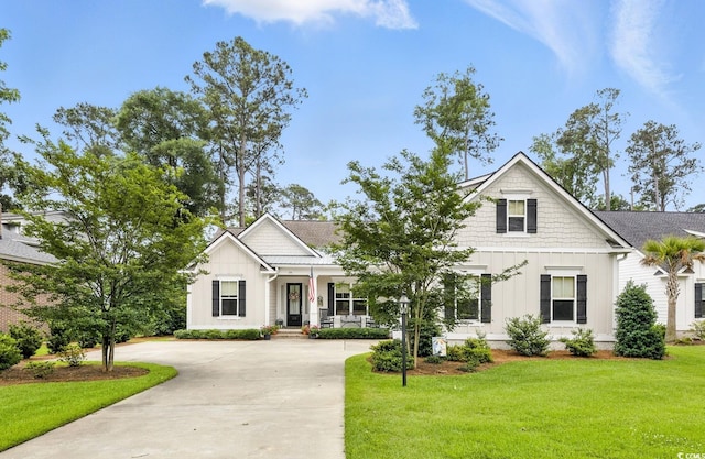 175 Chapel Creek Rd, Pawleys Island, SC 29585 - view of front of home with board and batten siding, a front yard, and driveway