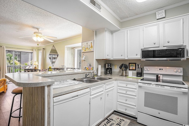 207 N Ocean Blvd Unit 139, North Myrtle Beach, SC 29582 - kitchen featuring white appliances, a textured ceiling, a peninsula, white cabinetry, and light countertops