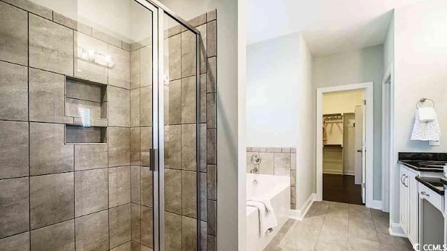 1012 Fowler Rd, Conway, SC 29526 - bathroom featuring vanity, a bath, a shower stall, a walk in closet, and tile patterned flooring
