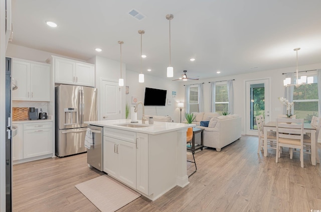 5116 Double Eagle Way Unit 49, North Myrtle Beach, SC 29582 - kitchen with stainless steel appliances, light wood-type flooring, white cabinetry, backsplash, and open floor plan