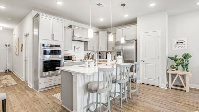 5205 Double Eagle Way Unit 24, North Myrtle Beach, SC 29582 - kitchen featuring stainless steel appliances, light countertops, light wood-style floors, a kitchen bar, and recessed lighting