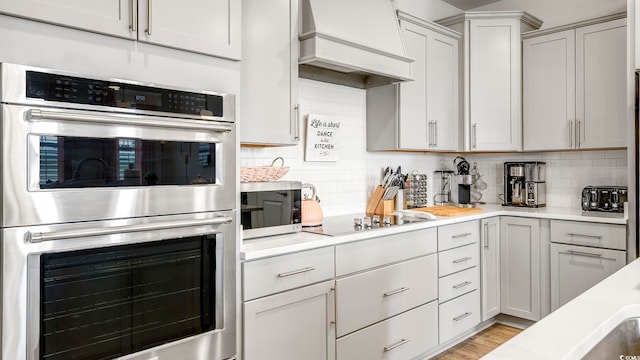 5205 Double Eagle Way Unit 24, North Myrtle Beach, SC 29582 - kitchen featuring appliances with stainless steel finishes, premium range hood, light countertops, and tasteful backsplash