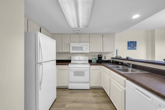 201 74th Ave N Unit 703, Myrtle Beach, SC 29572 - kitchen featuring white appliances, dark countertops, light wood-style flooring, white cabinetry, and recessed lighting