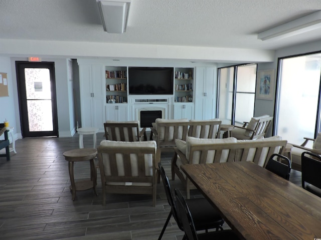 2500 N Ocean Blvd Unit 709, North Myrtle Beach, SC 29582 - living area with healthy amount of natural light, a textured ceiling, dark wood-style flooring, and a fireplace