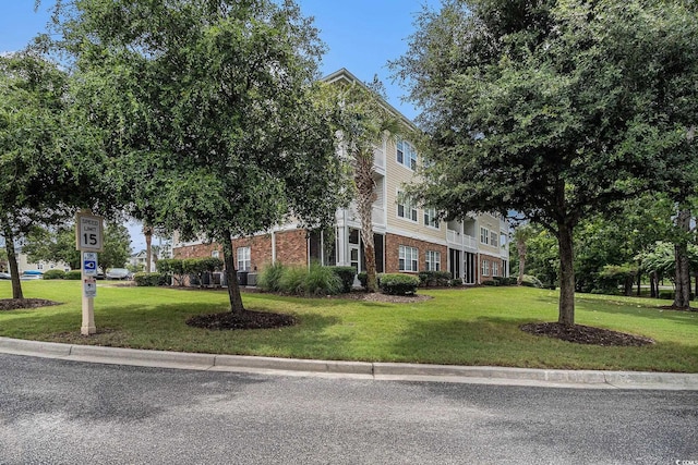 5801 Oyster Catcher Dr Unit 324, North Myrtle Beach, SC 29582 - obstructed view of property with brick siding and a front lawn