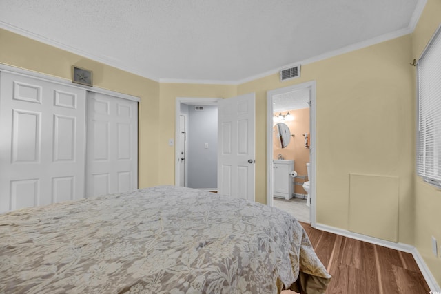 1100 Possum Trot Rd Unit E238, North Myrtle Beach, SC 29582 - bedroom with crown molding, wood finished floors, a closet, and connected bathroom