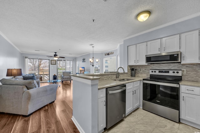 1100 Possum Trot Rd Unit E238, North Myrtle Beach, SC 29582 - kitchen featuring stainless steel appliances, a peninsula, open floor plan, white cabinets, and a textured ceiling