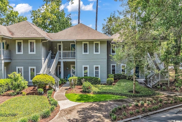 1221 Tidewater Dr Unit 911, North Myrtle Beach, SC 29582 - view of front facade featuring stairs, roof with shingles, and a front lawn