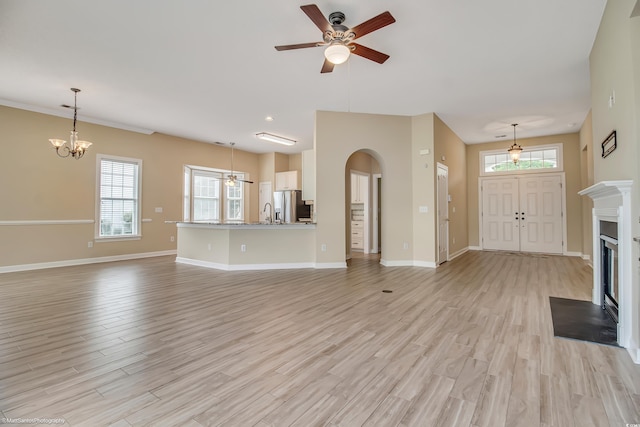 2901 Whooping Crane Dr, North Myrtle Beach, SC 29582 - unfurnished living room with a ceiling fan, light wood-style flooring, a fireplace with flush hearth, and healthy amount of natural light