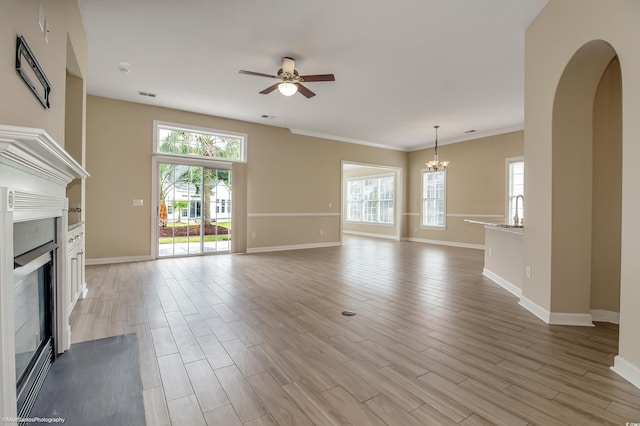 2901 Whooping Crane Dr, North Myrtle Beach, SC 29582 - unfurnished living room featuring a fireplace, a ceiling fan, plenty of natural light, a chandelier, and crown molding