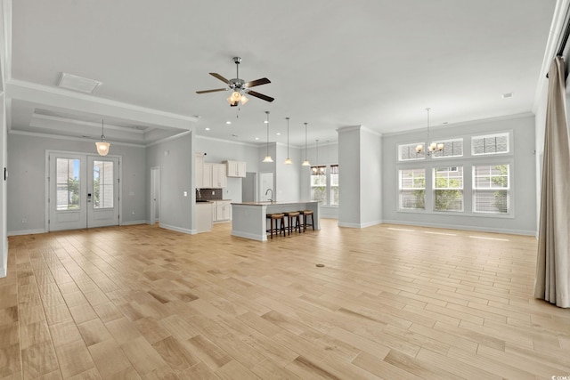 957 Bronwyn Cir N, Myrtle Beach, SC 29582 - unfurnished living room featuring plenty of natural light, ornamental molding, ceiling fan, a chandelier, and light wood-style flooring