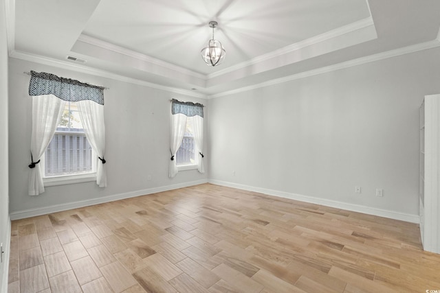 957 Bronwyn Cir N, Myrtle Beach, SC 29582 - unfurnished room with a tray ceiling, healthy amount of natural light, a chandelier, light wood-style flooring, and crown molding