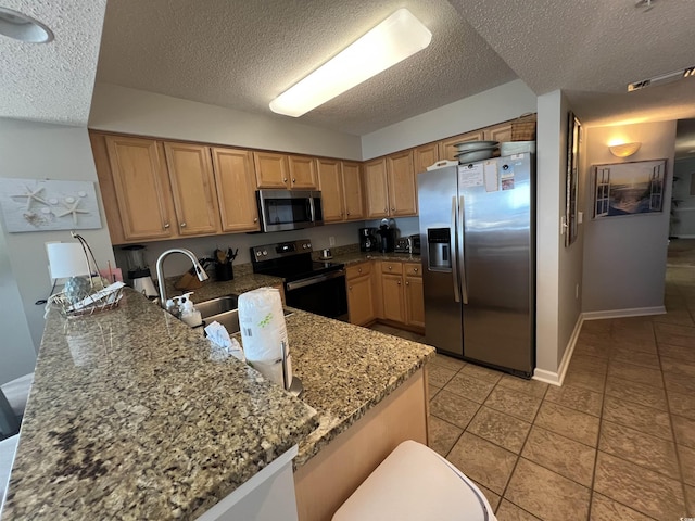1401 S Ocean Blvd Unit 1307, North Myrtle Beach, SC 29582 - kitchen with appliances with stainless steel finishes, a peninsula, a textured ceiling, stone counters, and light tile patterned flooring
