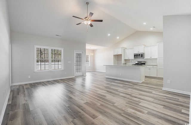 442 Lifestyle Ct, Surfside Beach, SC 29575 - unfurnished living room with a ceiling fan, light wood-style floors, high vaulted ceiling, recessed lighting, and a chandelier