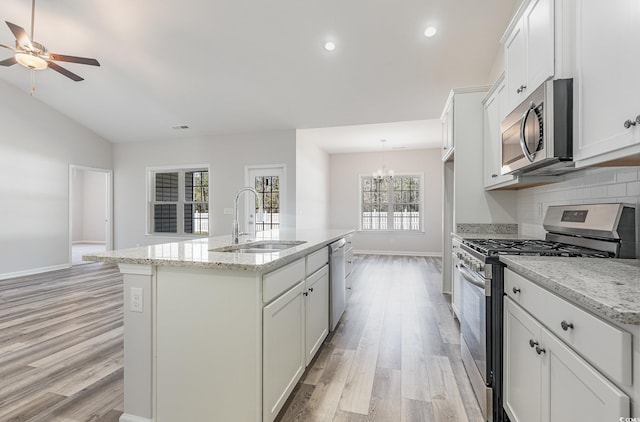 442 Lifestyle Ct, Surfside Beach, SC 29575 - kitchen with stainless steel appliances, a chandelier, light wood-type flooring, backsplash, and a kitchen island with sink