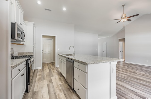 442 Lifestyle Ct, Surfside Beach, SC 29575 - kitchen with stainless steel appliances, light wood finished floors, ceiling fan, white cabinets, and a kitchen island with sink