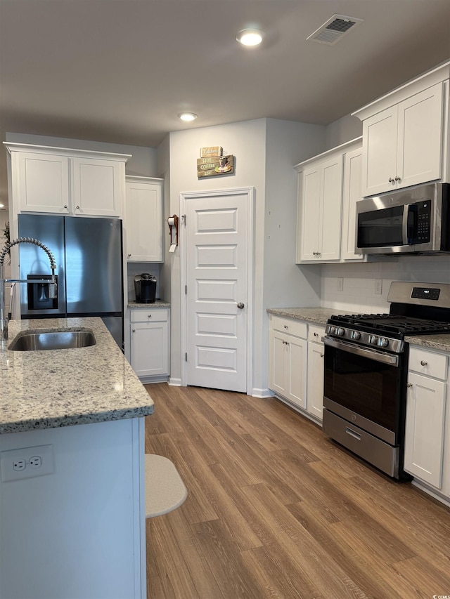 3085 Sistine St, Myrtle Beach, SC 29579 - kitchen featuring stainless steel appliances, wood finished floors, white cabinetry, light stone countertops, and recessed lighting