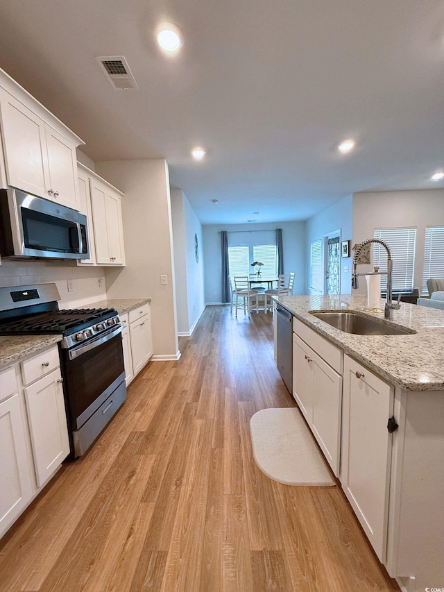 3085 Sistine St, Myrtle Beach, SC 29579 - kitchen with appliances with stainless steel finishes, white cabinets, light wood-style floors, light stone counters, and recessed lighting
