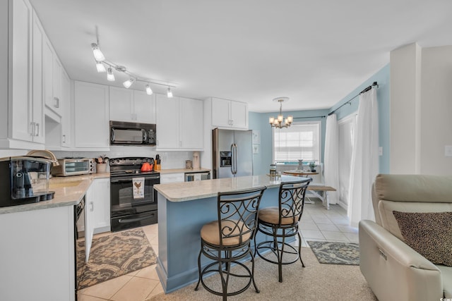 1500 Cenith Dr Unit E302, North Myrtle Beach, SC 29582 - kitchen with black appliances, a chandelier, white cabinetry, a breakfast bar, and a kitchen island