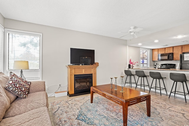 351 Lake Arrowhead Rd Unit 24-193, Myrtle Beach, SC 29572 - living area featuring light wood-type flooring, a textured ceiling, ceiling fan, recessed lighting, and a glass covered fireplace