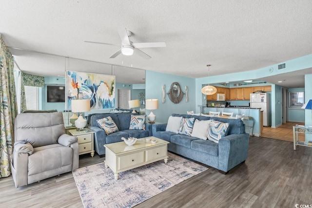 1625 S Ocean Blvd Unit 107, North Myrtle Beach, SC 29582 - living area featuring wood finished floors, a textured ceiling, and a ceiling fan