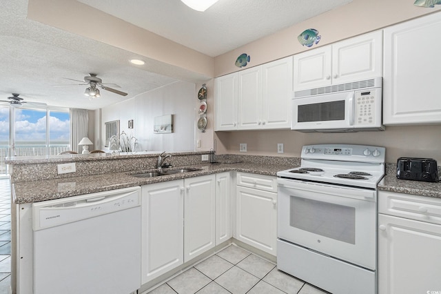 102 N Ocean Blvd Unit 508, North Myrtle Beach, SC 29582 - kitchen featuring white appliances, a peninsula, a textured ceiling, white cabinets, and light tile patterned flooring