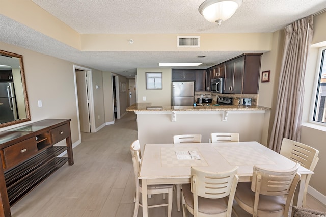 2000 N Ocean Blvd Unit 1117, Myrtle Beach, SC 29577 - dining space featuring a textured ceiling and light wood-style flooring