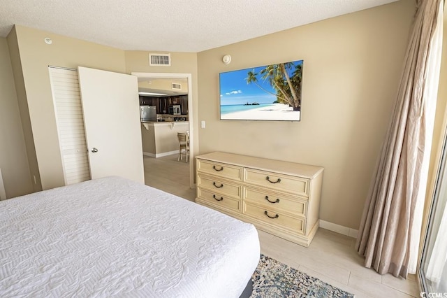 2000 N Ocean Blvd Unit 1117, Myrtle Beach, SC 29577 - bedroom with freestanding refrigerator and a textured ceiling