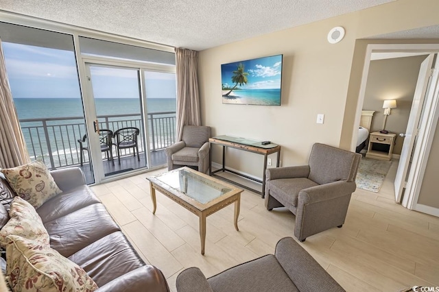 2000 N Ocean Blvd Unit 1117, Myrtle Beach, SC 29577 - living room featuring a wall of windows, a textured ceiling, and light wood finished floors