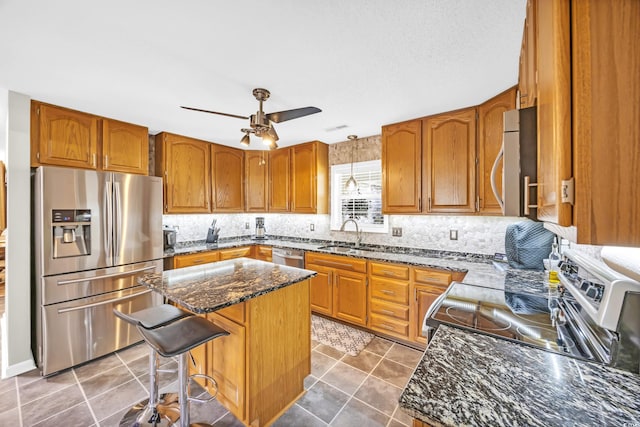 209 Chickasaw Ln, Myrtle Beach, SC 29579 - kitchen featuring stainless steel appliances, brown cabinets, ceiling fan, and decorative backsplash