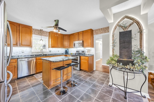 209 Chickasaw Ln, Myrtle Beach, SC 29579 - kitchen with stainless steel appliances, a center island, dark tile patterned floors, decorative backsplash, and ceiling fan