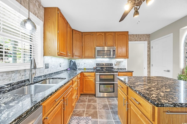 209 Chickasaw Ln, Myrtle Beach, SC 29579 - kitchen with stainless steel appliances, ceiling fan, backsplash, brown cabinetry, and dark stone counters