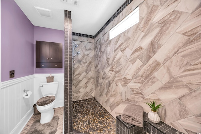 209 Chickasaw Ln, Myrtle Beach, SC 29579 - bathroom featuring tiled shower and a wainscoted wall