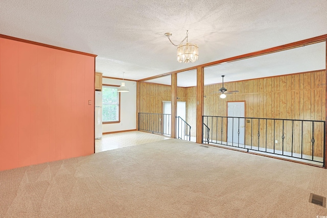 3916 Quail Cir, Myrtle Beach, SC 29579 - carpeted spare room featuring a chandelier, ornamental molding, wood walls, ceiling fan, and a textured ceiling