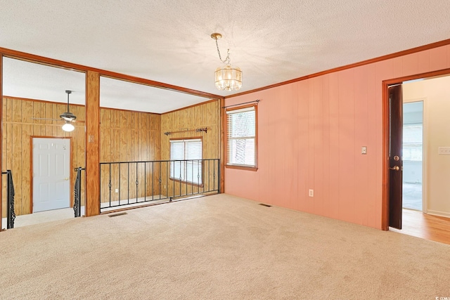 3916 Quail Cir, Myrtle Beach, SC 29579 - carpeted empty room featuring ornamental molding, a chandelier, wood walls, and a textured ceiling