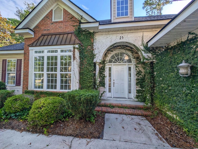 25 Deloach Trl, Pawleys Island, SC 29585 - view of exterior entry with brick siding and a standing seam roof