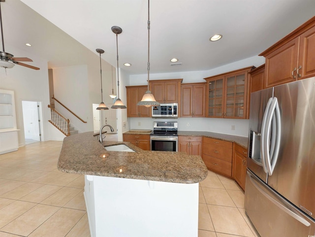 25 Deloach Trl, Pawleys Island, SC 29585 - kitchen featuring stainless steel appliances, light tile patterned floors, brown cabinets, a center island with sink, and recessed lighting
