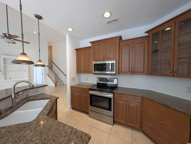 25 Deloach Trl, Pawleys Island, SC 29585 - kitchen featuring stainless steel appliances, light tile patterned flooring, dark stone counters, glass insert cabinets, and recessed lighting