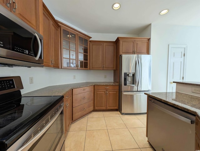 25 Deloach Trl, Pawleys Island, SC 29585 - kitchen with stainless steel appliances, stone counters, recessed lighting, light tile patterned flooring, and brown cabinetry