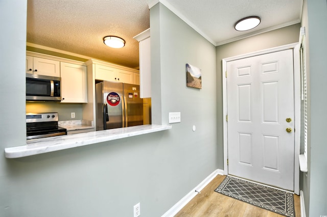 2187 Clearwater Dr Unit H, Surfside Beach, SC 29575 - foyer featuring light wood-type flooring, a textured ceiling, and ornamental molding