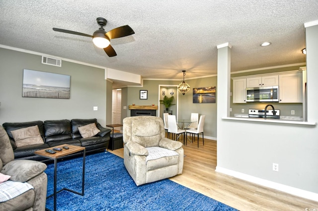 2187 Clearwater Dr Unit H, Surfside Beach, SC 29575 - living area featuring wood finished floors, ceiling fan, ornamental molding, a textured ceiling, and a fireplace