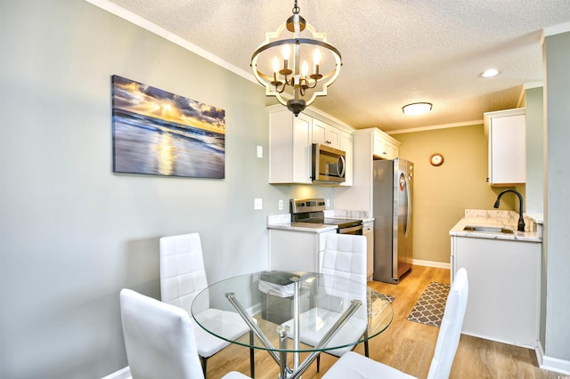 2187 Clearwater Dr Unit H, Surfside Beach, SC 29575 - dining area featuring a textured ceiling, light wood-type flooring, a chandelier, and crown molding