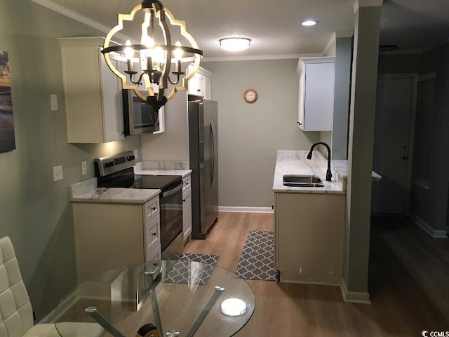 2187 Clearwater Dr Unit H, Surfside Beach, SC 29575 - kitchen featuring stainless steel appliances, light wood-type flooring, ornamental molding, a chandelier, and white cabinetry