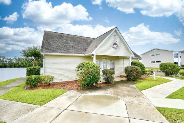 2187 Clearwater Dr Unit H, Surfside Beach, SC 29575 - view of front of house featuring a shingled roof, a front yard, and a water view