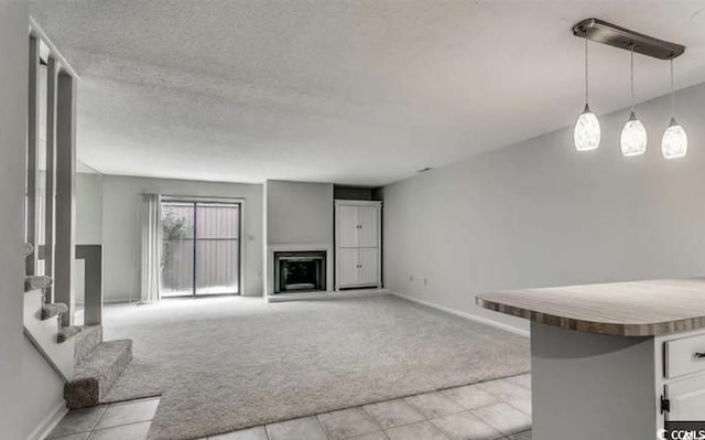 405 77th Ave N Unit 5, Myrtle Beach, SC 29572 - unfurnished living room featuring light carpet, light tile patterned floors, stairway, a fireplace, and a textured ceiling