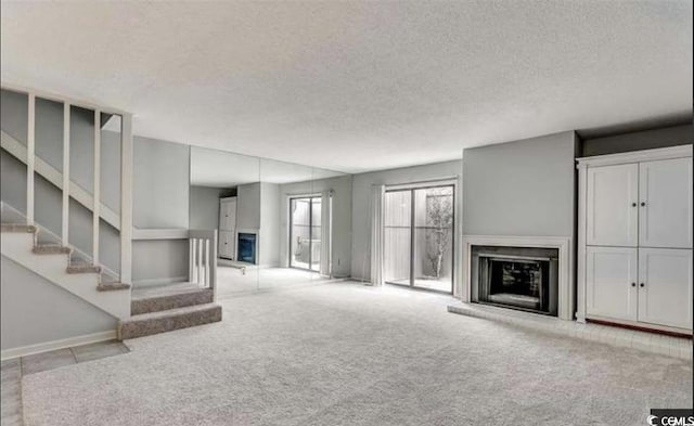 405 77th Ave N Unit 5, Myrtle Beach, SC 29572 - unfurnished living room with a fireplace, carpet, a textured ceiling, and stairway