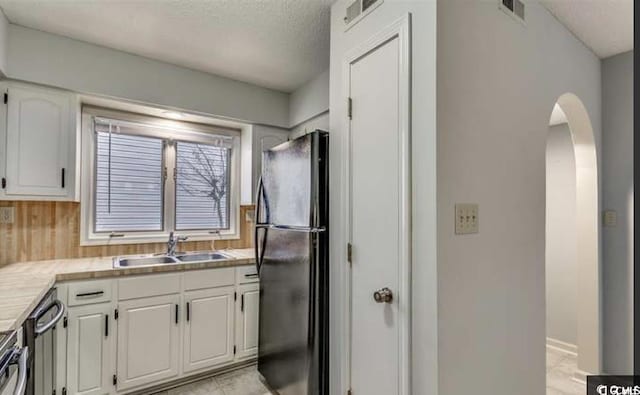 405 77th Ave N Unit 5, Myrtle Beach, SC 29572 - kitchen with freestanding refrigerator, arched walkways, white cabinets, light countertops, and dishwasher