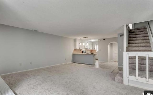 405 77th Ave N Unit 5, Myrtle Beach, SC 29572 - unfurnished living room featuring arched walkways, light carpet, and stairway